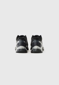 Black and grey athletic shoes with a mesh upper, cushioned sole, and reflective accents, featuring a rounded and ergonomic design.