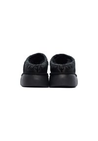 Scarpe slip-on nere con una morbida fodera pelosa e un retro arrotondato. Il materiale esterno è liscio con minime cuciture e una suola in gomma piatta.