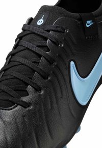 Black football shoe featuring a textured leather upper with blue accent swoosh, black laces, and a round logo on the tongue.