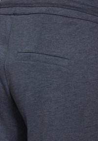 Dunkelgraue Hosen aus strukturiertem Stoff, mit einer einzelnen Gesäßtasche mit horizontaler Öffnung und subtilen Nähdetails.