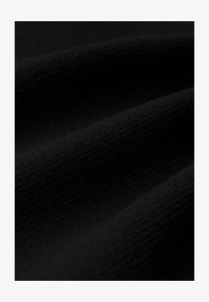Juodas tekstūruotas audinys su minkštu, suribotu paviršiumi, demonstruojantis subtilų gylį ir banguojančias raukšles. Tinka įvairiems drabužiams.