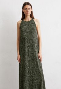 Maxikleid aus dunkelgrünem Stoff mit einem gepunkteten Muster. Es hat einen runden Ausschnitt und eine lockere Silhouette, die eine entspannte Passform bietet.