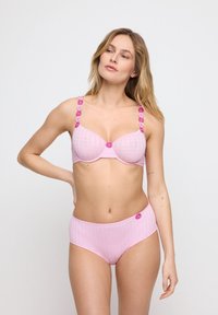 Ljusrosa underklädesset med en texturerad mönster. Bh:n har formade kupor och blomdetaljer på axelbanden; högmidjade trosor matchar designen.