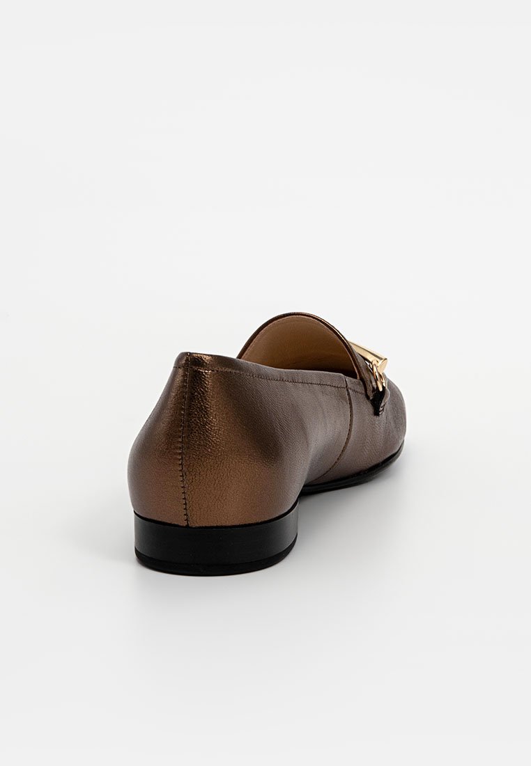 Braune Lederflats mit schwarzer Sohle, von hinten auf einem weißen Hintergrund betrachtet, mit goldener Schnalle oben.