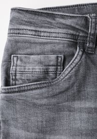 Grijze denim jeans met een voorzak, stikdetails en een gladde textuur. De tailleband toont een label met de maat.