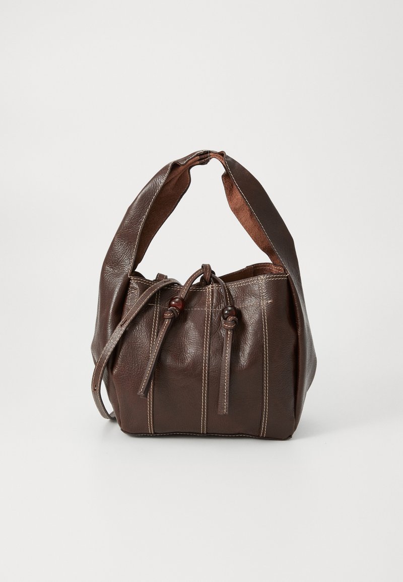Sac en cuir brun avec une texture douce, de forme arrondie, et un compartiment principal sécurisé par des cordons de serrage. Présente des coutures contrastées et une anse souple.