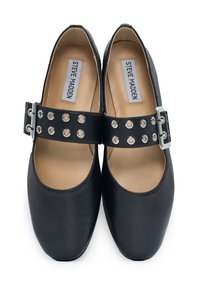 Czarne buty typu Mary Jane z zaokrąglonym noskiem, wyposażone w szeroki pasek wokół kostki ozdobiony srebrnymi ćwiekami i metalowym zapięciem. Gładka tekstura.