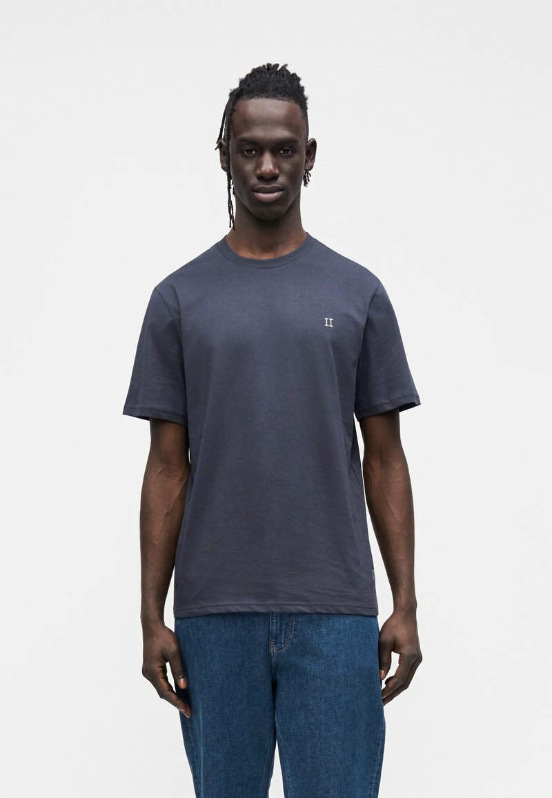 Granatowy bawełniany t-shirt z krótkimi rękawami, okrągłym dekoltem oraz małym białym logo "II" na lewej piersi. Luźny krój, bez widocznych wzorów czy akcentów.