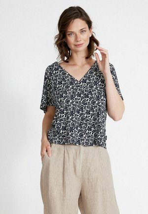 Top corto blu navy con stampa floreale, design a V e vestibilità rilassata. Il materiale sembra leggero e morbido, adatto per un abbigliamento informale.