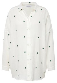 Chemise blanche à boutons, fabriquée en tissu texturé, ornée de motifs de cœurs verts dispersés, avec des manches longues et un col classique.