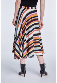 Jupe A-line rayée présentant des rayures verticales multicolores en noir, orange, rose et blanc, avec un tissu lisse et léger et un design plissé.