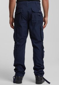 Marinblå cargobyxor med flera sidofickor, en lös passform och ett slitstarkt tyg. Har justerbara muddar och förstärkta sömmar.