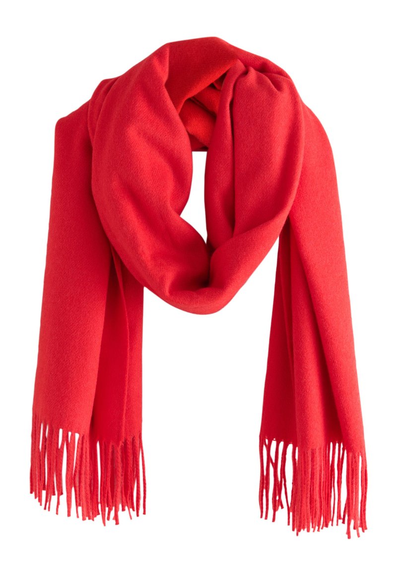 Écharpe en laine rouge aux bords frangés, présentant une texture douce et un drapé circulaire. La couleur vive renforce son impact visuel.