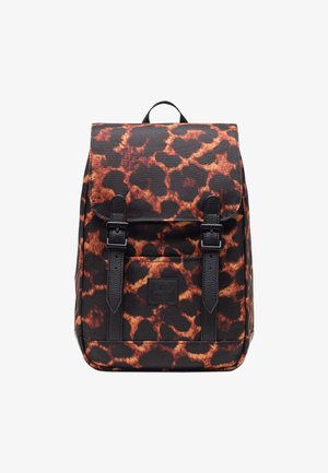 Mochila con una base de tela negra que presenta un patrón de manchas de leopardo marrón. Incluye correas negras y un asa superior. Cierres de hebilla ajustables.