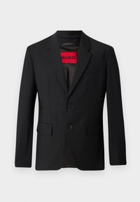Black blazer with two buttons, notch lapels, and flap pockets. Lined with a red label reading "HUGO." Smooth fabric with a tailored fit.