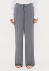 Γκρίζα παντελόνια σε φαρδιά γραμμή, κατασκευασμένα από μαλακό, ελαφρύ ύφασμα. Διαθέτουν ελαστική μέση με κορδόνι και χρυσές μεταλλικές λεπτομέρειες.