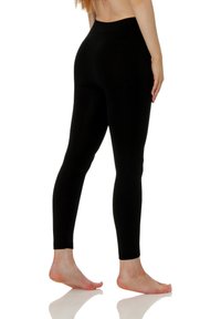 Leggings noirs en tissu extensible avec une taille haute, ajustés à la jambe et une texture lisse et mate.