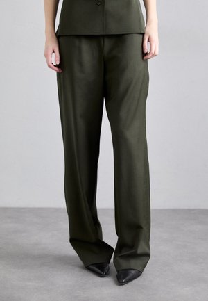 Pantalons larges vert olive en tissu lisse, dotés d'une taille haute et de drapés subtils, associés à des talons noirs pointus.