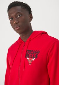 Roter Reißverschluss-Hoodie mit einem Chicago Bulls-Graphic auf der Brust, mit Kapuze und glattem Baumwollstoff.