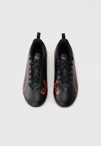 Μαύρα αθλητικά παπούτσια με υφασμάτινο συνθετικό επάνω μέρος με υφή, πορτοκαλί λεπτομέρειες και μαύρα κορδόνια. Διαθέτουν λογότυπο στη γλώσσα και στο πλευρό. Επίπεδη σόλα.