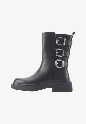 Czarne skórzane botki za kostkę z trzema srebrnymi zapięciami, gładka tekstura, okrągły czubek i gruba, płaska podeszwa.