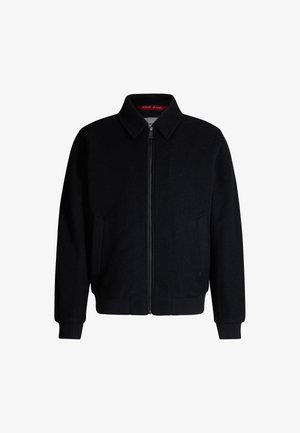 Czarna wełniana kurtka bombowiec z zamkiem z przodu, stojącym kołnierzem oraz ściągaczami przy mankietach i u dołu. Posiada boczne kieszenie oraz wykończenie podszewki w kolorze czerwonym.