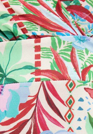 Lyst tropisk stof med røde, grønne og blå blade, geometriske mønstre og overlappende folder, der skaber tekstur og dybde.