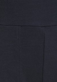 Tissu bleu marine foncé avec un tissage texturé visible et des détails de couture verticale.