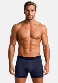 Laivastonsiniset raidalliset boksershortsit istuvalla leikkauksella. Valmistettu pehmeästä kankaasta, jossa leveä vyötärönauha ja muotoiltu pussiosa mukavuutta varten.