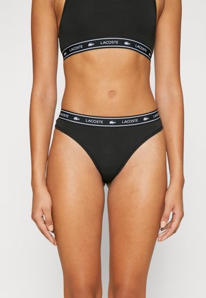 Black cotton underwear with a high-cut design, featuring a contrasting waistband with the Lacoste logo in white and a stylized crocodile.