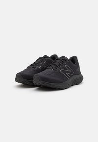 Zapatillas deportivas negras que cuentan con una parte superior de malla transpirable, suelas texturizadas y un diseño minimalista con líneas de acento sutiles.