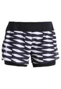 Svartvita mönstrade träningsshorts med zickzackmönster, en svart midja och en slät yta med två sidofickor.