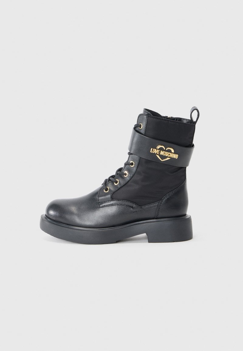 Crne čizme na vezanje u kombinaciji glatke kože i najlona, s zlatnim logotipom "LOVE MOSCHINO" i debelim crnim đonom.