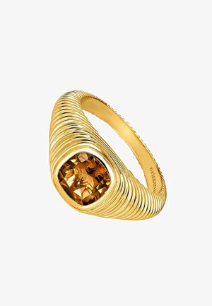 Anillo dorado con un diseño acanalado torcido que presenta una gran gema de ámbar en corte cuadrado, mostrando un intrincado facetado y superficies reflectantes.