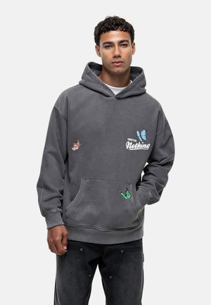 Sweatshirt à capuche gris avec une poche avant, orné de broderies de papillons colorés. Fabriqué en tissu doux, il a une coupe décontractée et des poignets côtelés.