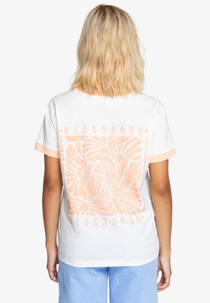 Camiseta blanca con detalles en durazno; presenta un diseño floral en línea y el logo de la marca en la parte posterior. Mangas cortas, tela suave.