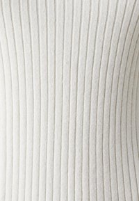 Biały, prążkowany materiał o miękkiej fakturze, z pionowymi liniami i subtelnym połyskiem, podkreślający luksusową jakość tkaniny.