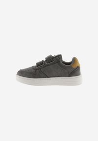 Zapatilla de piel gris con doble tiras de Velcro, suela de goma blanca, puntera redondeada y un pequeño acento marrón en el talón.