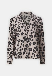 Blouse imprimée léopard avec des manches longues, taches noires sur un fond beige, fermeture par boutons et col. Texture lisse.