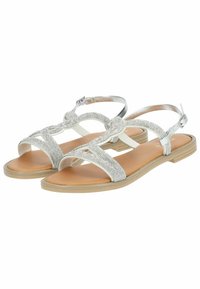 Zilveren sandalen met een gevlochten bandontwerp, voorzien van een platte zool en een verstelbare enkelgesp. Gladde textuur en lichte kleur.