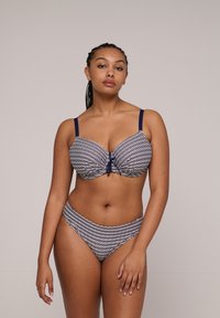 Dwuczęściowy strój kąpielowy w niebiesko-białe paski. Biustonosz z fiszbinami, z twistowym detalem na środku oraz regulowanymi ramiączkami. Wysokie majtki z podobnym wzorem.