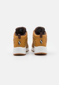 Brown high-top sneakers with white soles, leather material, padded collar, and logo detail on the heel. Stitched accents visible.