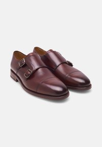 Chaussures habillées en cuir marron à double boucle, avec bout capsulé et boucles en argent, présentées sur un fond blanc.