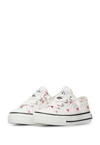 Scarpe da ginnastica bianche con pois neri e motivi a cuore rossi, caratterizzate da una punta tonda, suola in gomma e chiusura con lacci.