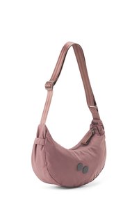 Sling-Umhängetasche aus weichem rosa Stoff mit runder Form, verstellbarem Tragegurt und zwei runden schwarzen Akzenten. Mit einem Reißverschlussverschluss.