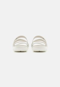 Et par hvide Crocs sandaler med åben hæl, flere vandrette stropper og struktureret sål for godt greb.