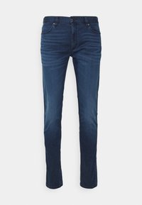 Tmavě modré slim-fit džíny s předními kapsami a jemným vyblednutím v oblastech stehna a kolen.