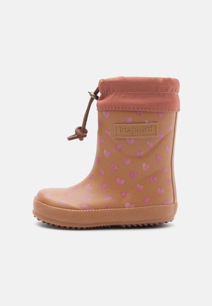 Botte de pluie en caoutchouc couleur caramel, avec un motif de cœurs roses, une semelle texturée marron et un revers en tissu avec cordon coulissant pour un ajustement réglable.