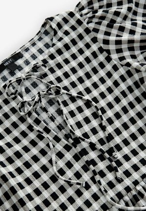Schwarz-weiße Karo-Bluse aus strukturiertem Stoff. Merkmale sind ein Schnürkragen mit Schleifen und Puffärmeln. Markenlabel sichtbar.