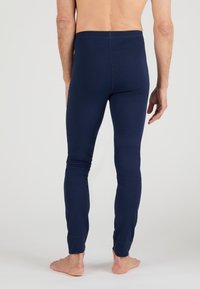 marineblaue Baumwollleggings mit taillierter Passform und elastischem Bund. Sie verfügen über eine glatte Textur und eng zulaufende Beine, die in gerippten Bündchen enden.
